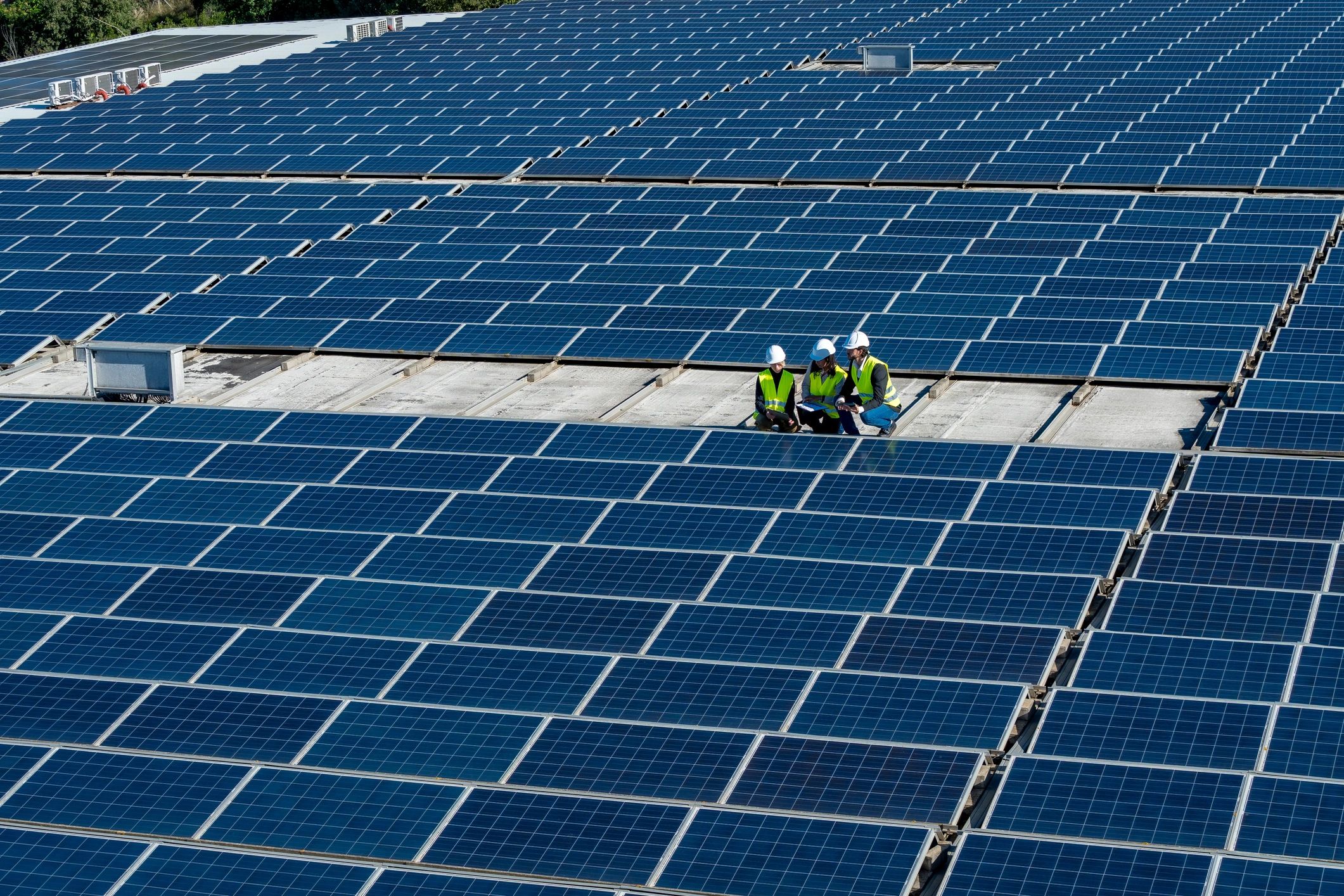 Engineers inspecting a commercial rooftop solar installation